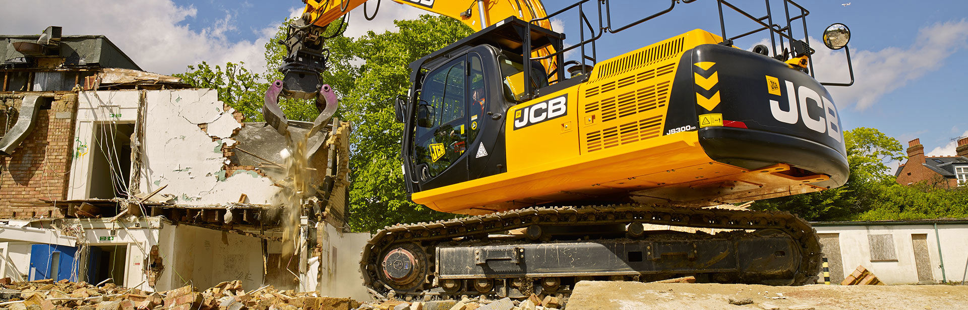 JCB Tracked Excavator demolishing an old building