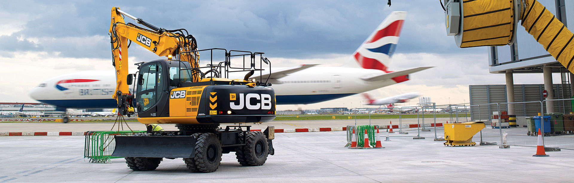 JCB wheeled excavator moving barriers at an airport